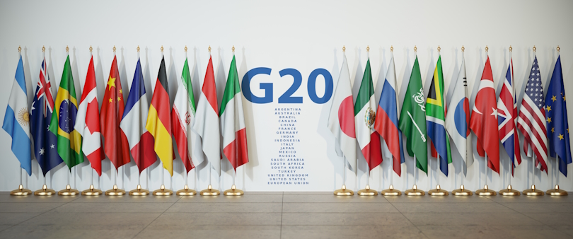 Die Flaggen der G20-Mitglieder stehen in einer Reihe vor einer Wand. In der Mitte der Wand sind die Mitglieder aufgelistet. Die Flaggen der G20-Mitglieder stehen in einer Reihe vor einer Wand. In der Mitte der Wand sind die Mitglieder aufgelistet.