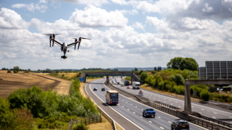 Eine Drohne fliegt neben einer Autobahn Eine Drohne fliegt neben einer Autobahn