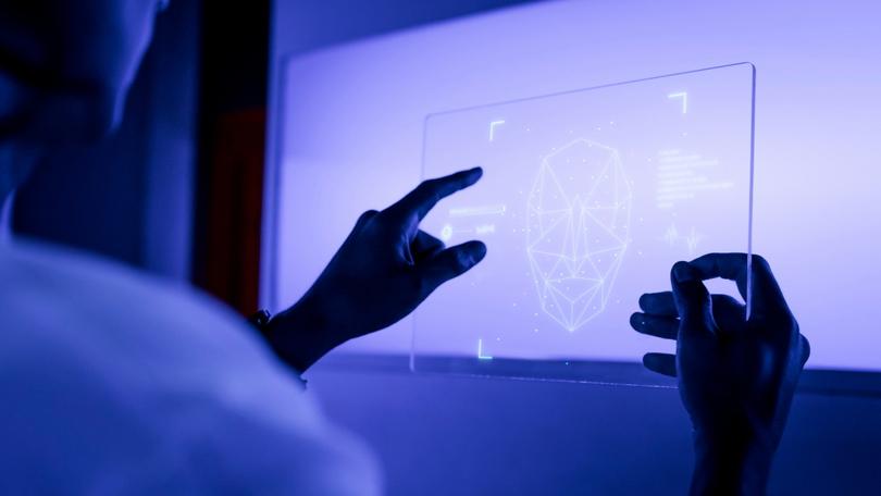 Eine Person hält eine Glasplatte mit einem Hologramm