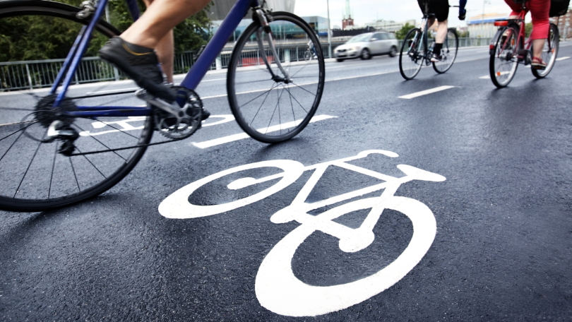 Mehrere Fahrräder fahren auf einem gekennzeichneten Radweg Mehrere Fahrräder fahren auf einem gekennzeichneten Radweg